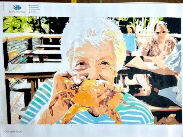 finished custom paint by numbers kit of an old lady holding a cooked crab